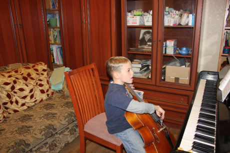 Our budding cellist in our crowded dining room